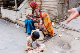 Dziecko-z-miska-i-kobiety-siedzace-na-ulicy-w-Pushkar-Indie