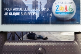 Bezdromny-na-ulicy-Paryza-pod-plakatem-UEFA
