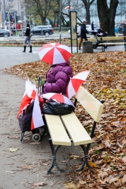 Sprzedawca-bialo-czerwonych-parasolek-na-lawce-w-parku-podczas-Narodowego-Świeta-Niepodleglosci-Pol