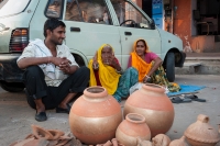 Trzy-osoby-siedza-na-ulicy-przy-samochodzie-w-Jaipur-Indie