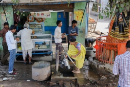 Kobieta-pompujaca-wode-do-baniek-z-ulicznej-studni-w-Varanasi