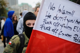 Dziewczyna-z-zakryta-twarza-i-flaga-z-haslami-anty-islamskimi-podczas-manifestacji-antyimigracyjnej-